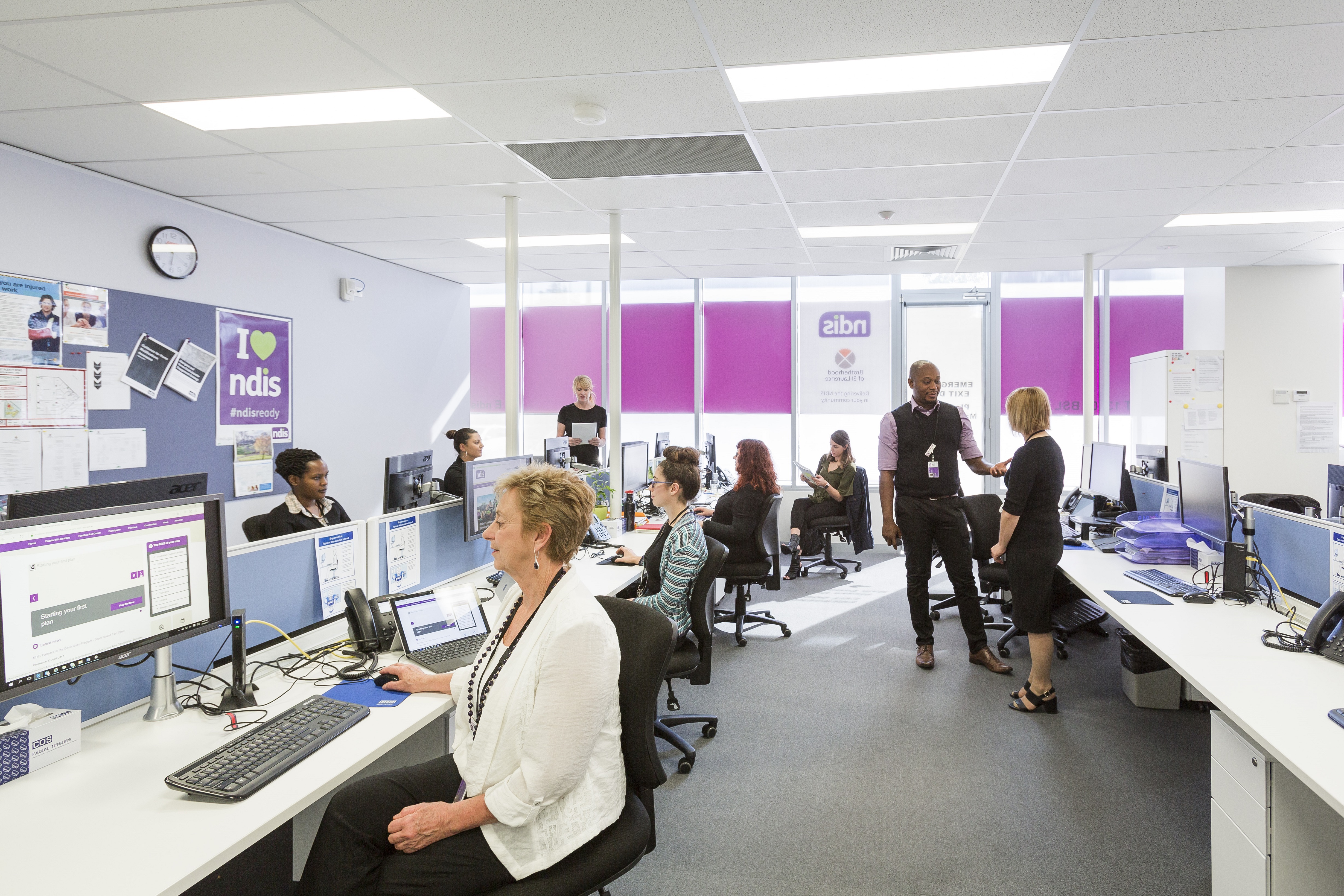 Image depicting the inside of a spacious and bright Brotherhood NDIS office with Brotherhood LAC staff working at their desks.