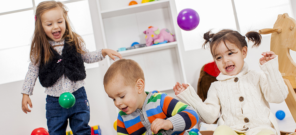Stock image of group of children playing with some toys in play group