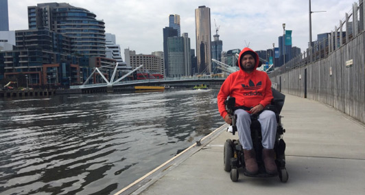 Mahmood in a wheelchair beside the Yarra River